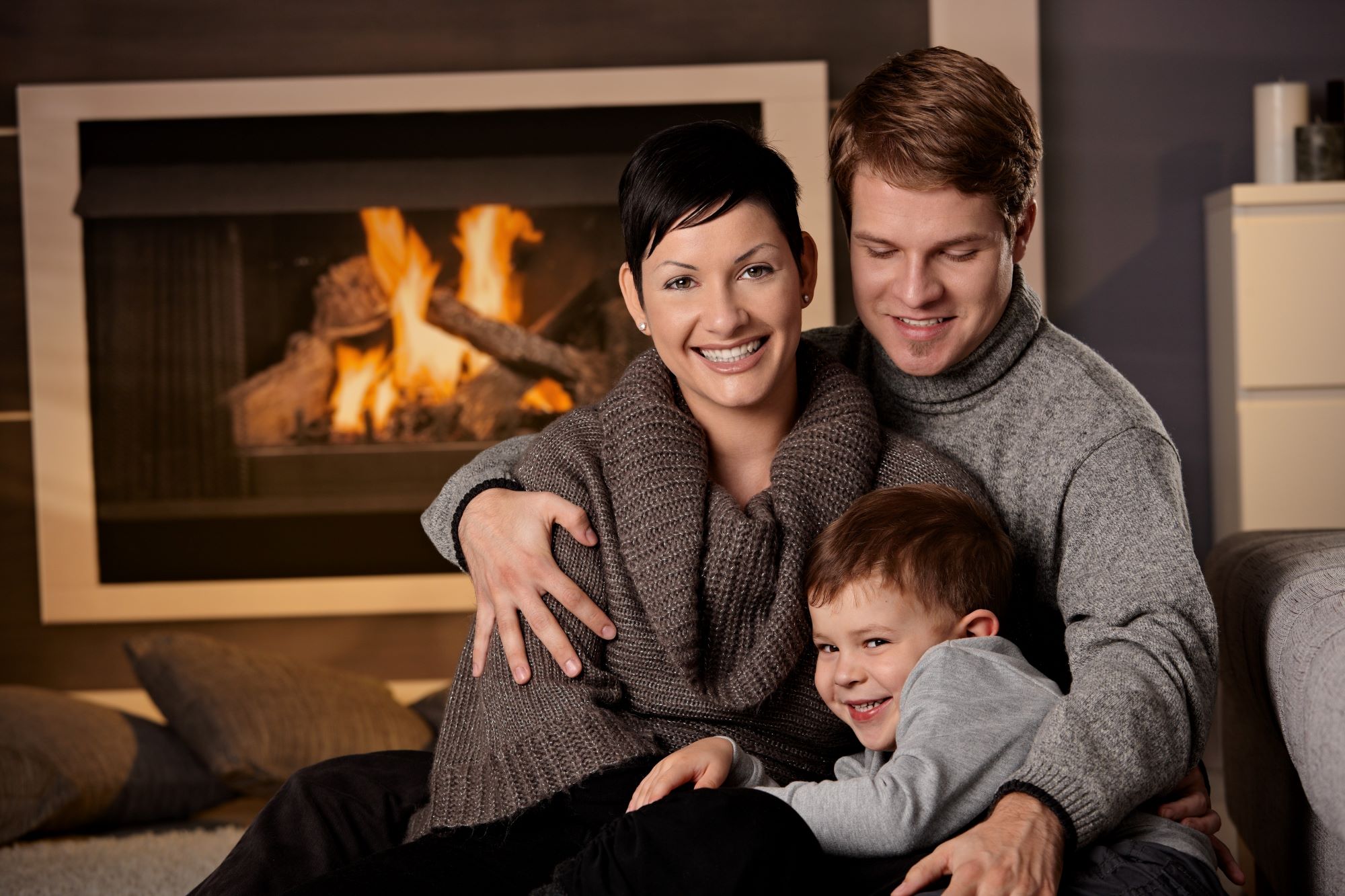 Family relaxing beside a fireplace
